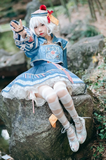 一尊穿着蓝色裙子的女孩坐在岩石上
