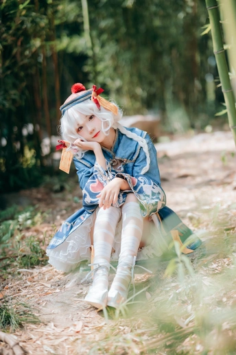 一个小女孩穿着服装坐在森林里地上