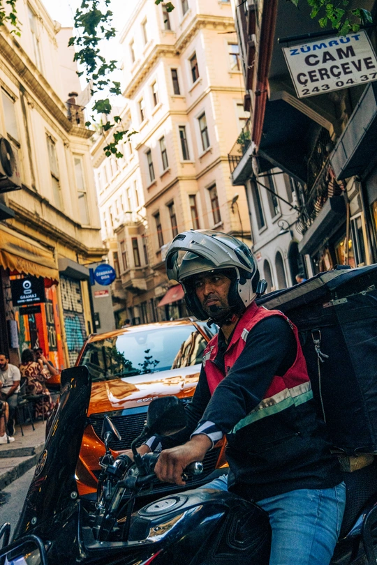 一个戴头盔的男子骑摩托车穿行城市街道