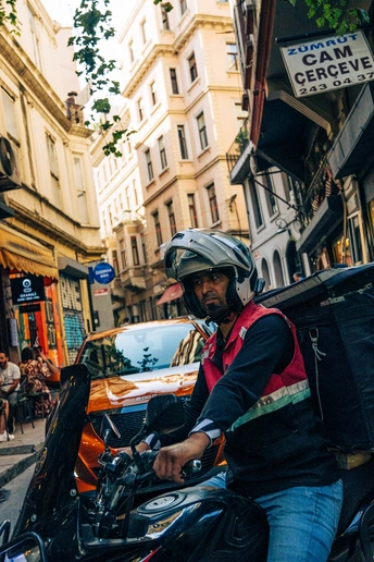 一个戴头盔的男子骑摩托车穿行城市街道