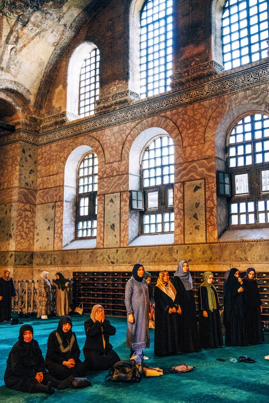 一些妇女坐在大型建筑物的地板上