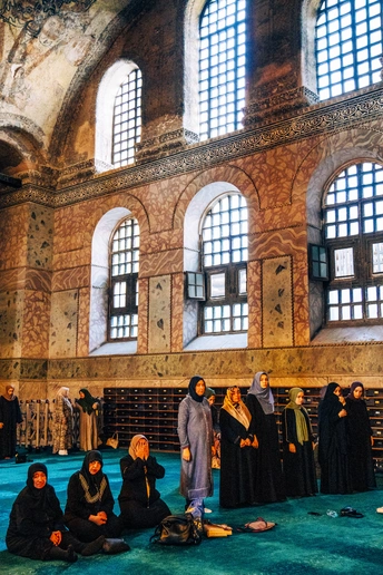 一些妇女坐在大型建筑物的地板上