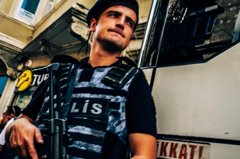 一个人正在沿着公交车旁的街道走