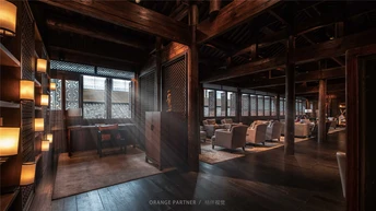 一个黑暗的房间 里面有一个酒吧和桌子椅子在一个大型建筑物中