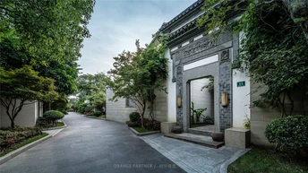 带有车道和道路两侧都有树木的房子的大门