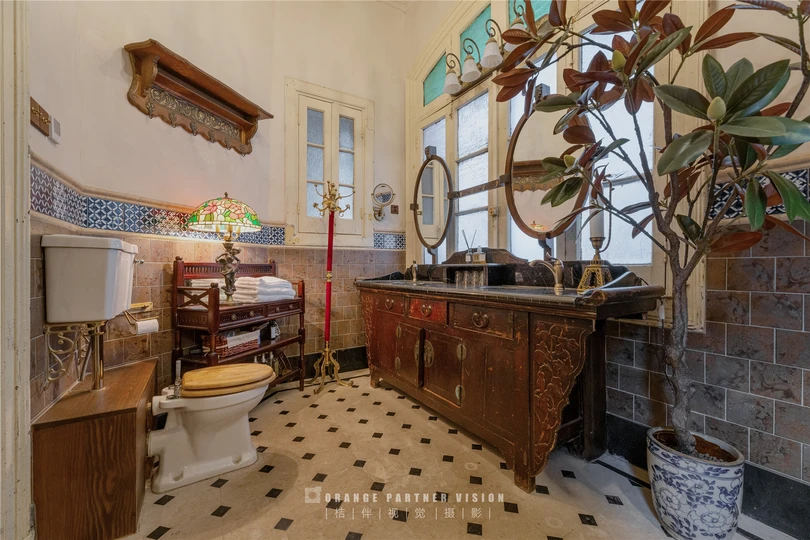 一个带有厕所、水槽、镜子和盆栽的浴室