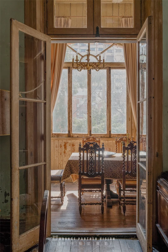 一个带木制桌椅和大型窗户的房间