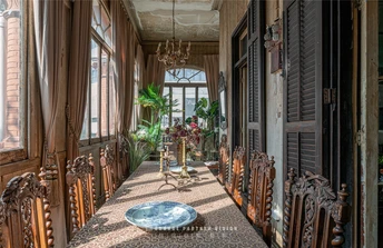 一个带有长桌和椅子的餐厅 有大型窗户和盆栽。