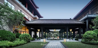 酒店前面的有一个庭院 前面有一个步行道和花园。