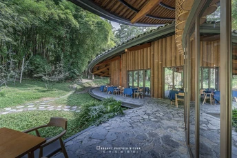 森林中央有一个大型凉亭 里面有桌子和椅子。