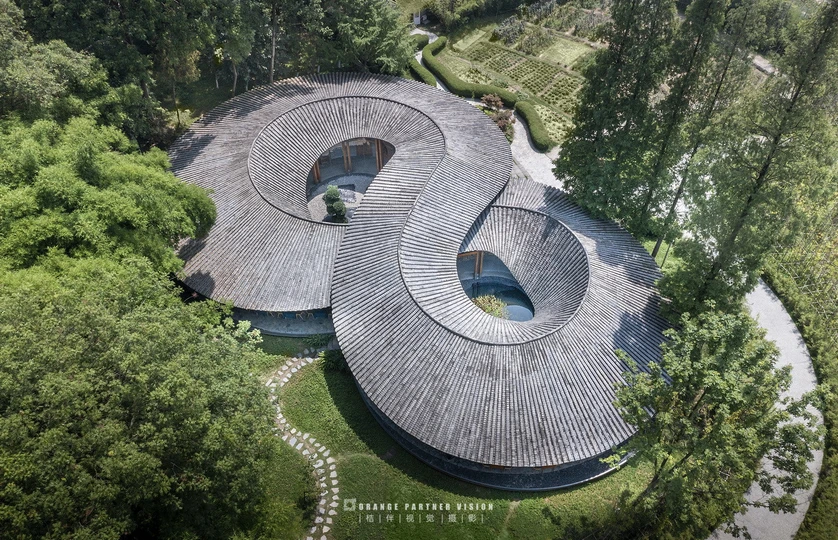 环绕森林的圆形住宅的 aerial view