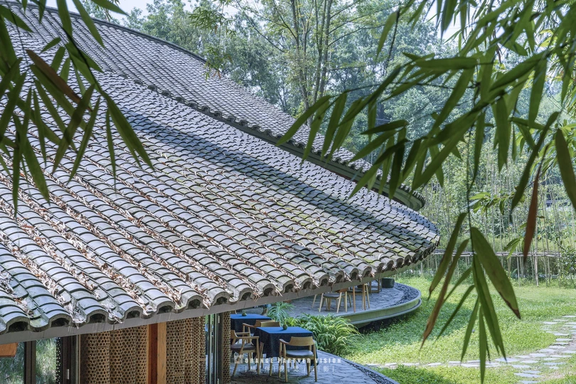 茅草屋顶的房屋旁边有一棵树