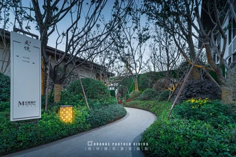 暮色中的人行道 有树木、灌木丛和位于小径一侧的大型标志。