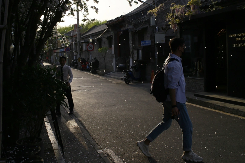 一个背着背包的男人走在一条空荡荡的街道上