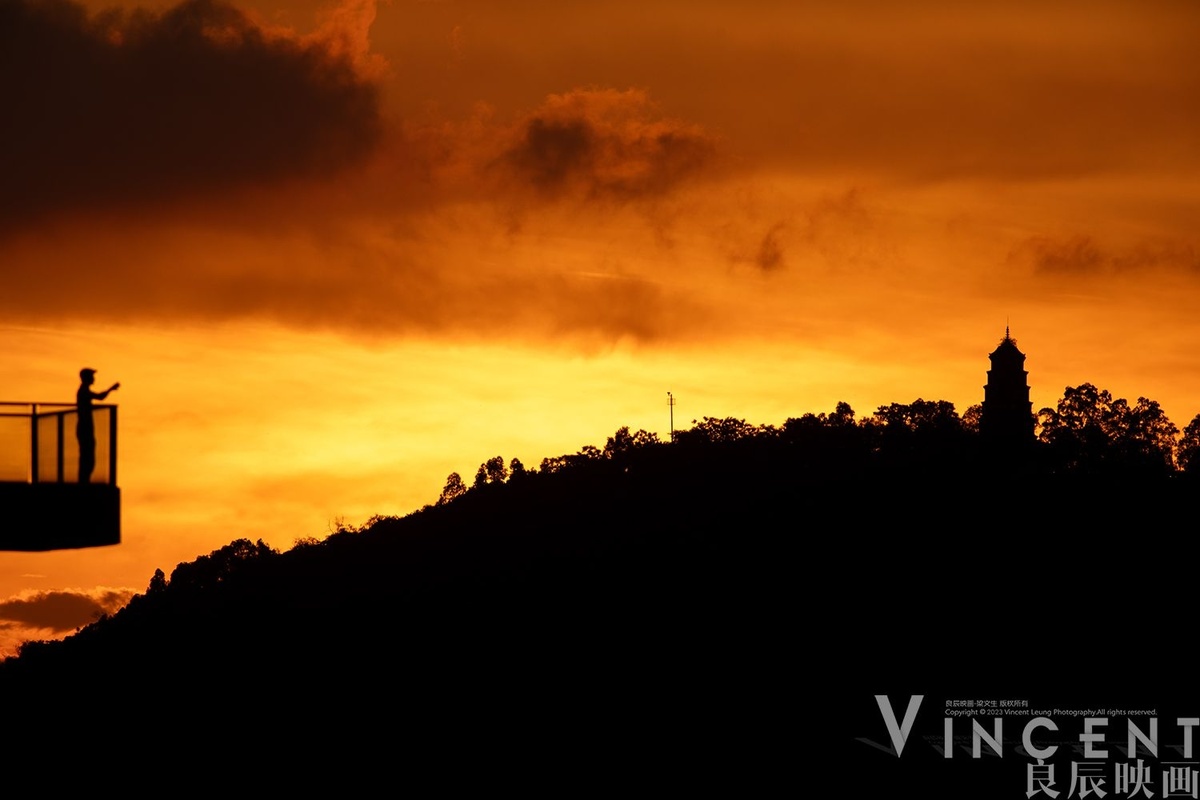夕阳下 站在山丘上的阳台上的一个人的剪影