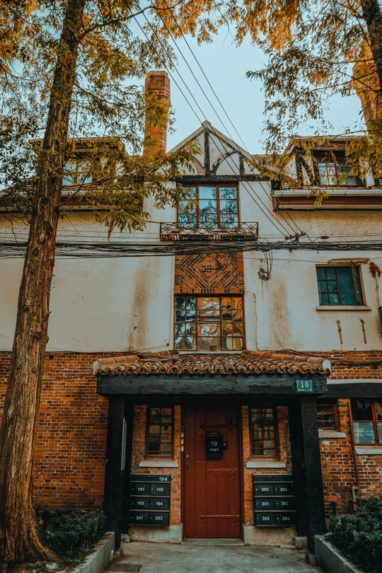 门前有一座老建筑和一些树。