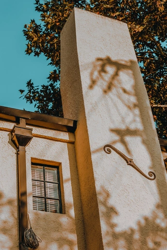 墙上的白色建筑的角落 树在墙上投下影子