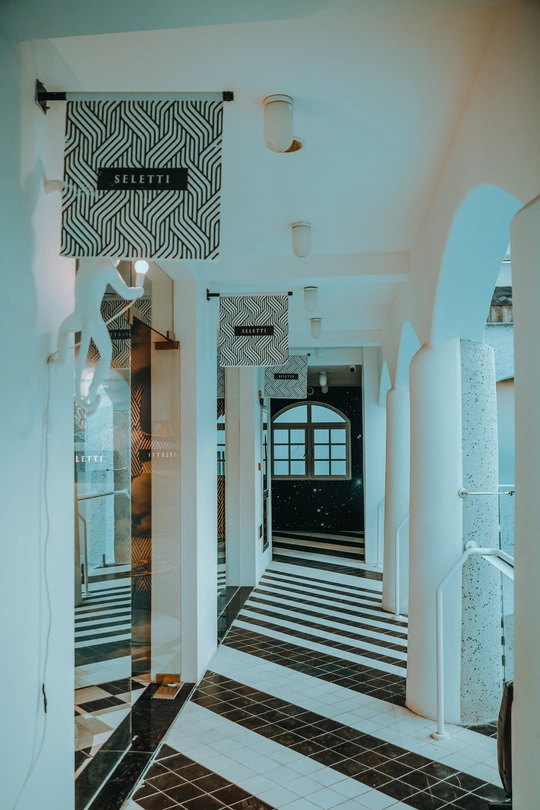 一条带有白色墙壁和黑白棋盘式地面的走廊