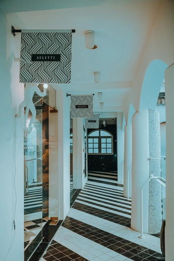 一条带有白色墙壁和黑白棋盘式地面的走廊