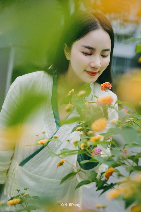 一个年轻女子在花园里摘一些花