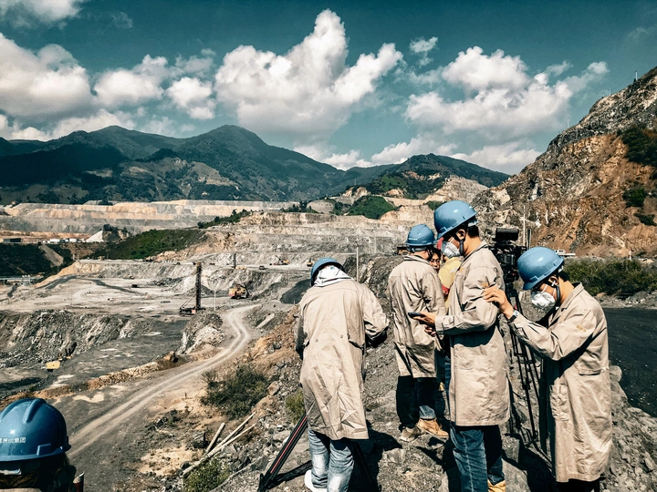 建筑工人站在一个采石场的一个地方 背景是山脉。