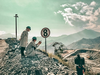 一个跪在地上靠近一个标志牌的女人站在路边