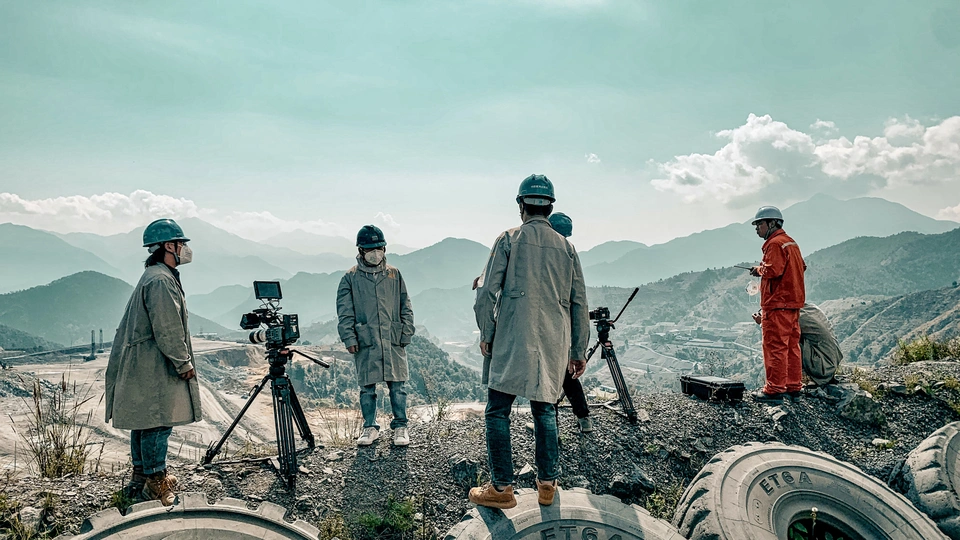 人们站在一个山坡上 有轮胎和相机。