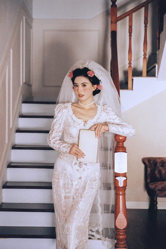 一位穿着白色婚纱和头纱的女子在楼梯上