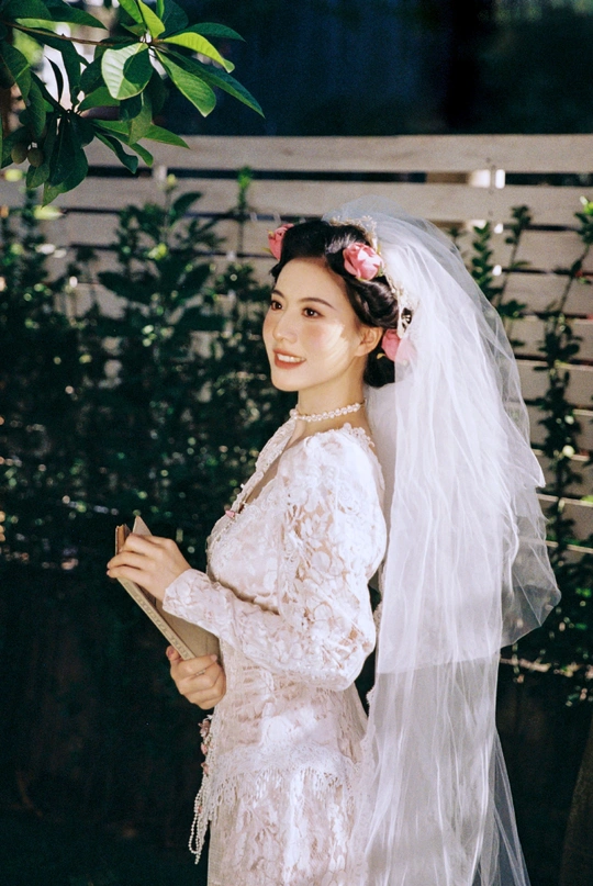 一位穿着白色婚纱和面纱参加婚礼的女人