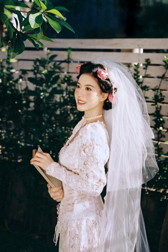 一位穿着白色婚纱和面纱参加婚礼的女人