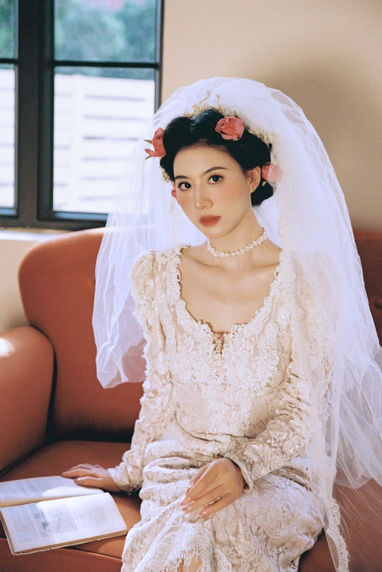 一位穿着白色婚纱和头纱的女士坐在沙发上