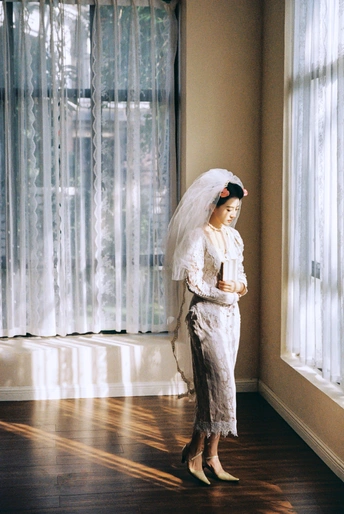 一位穿着白色婚纱的年轻女子站在一个房间里