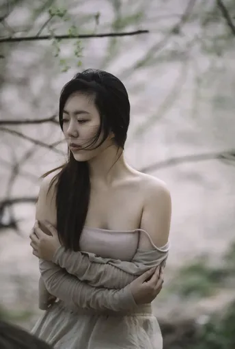 一位年轻女子手持雨伞站在森林中