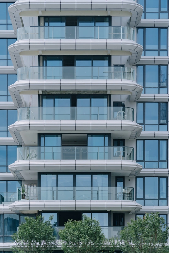 有许多窗户和阳台的现代化公寓楼的照片