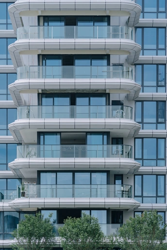 有许多窗户和阳台的现代化公寓楼的照片