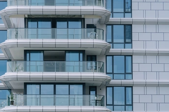 有蓝色窗户和阳台的高公寓楼