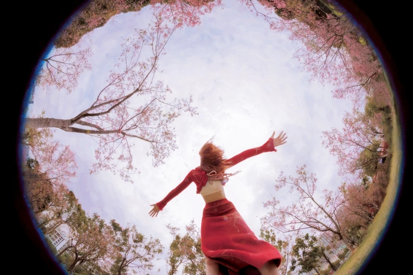 一位穿着红裙子的女人在空中跳跃