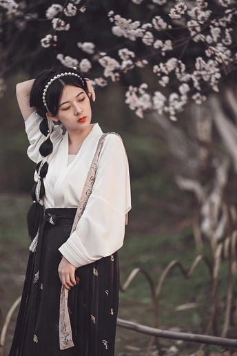 一个穿着黑色连衣裙、头发上插着白花的女人