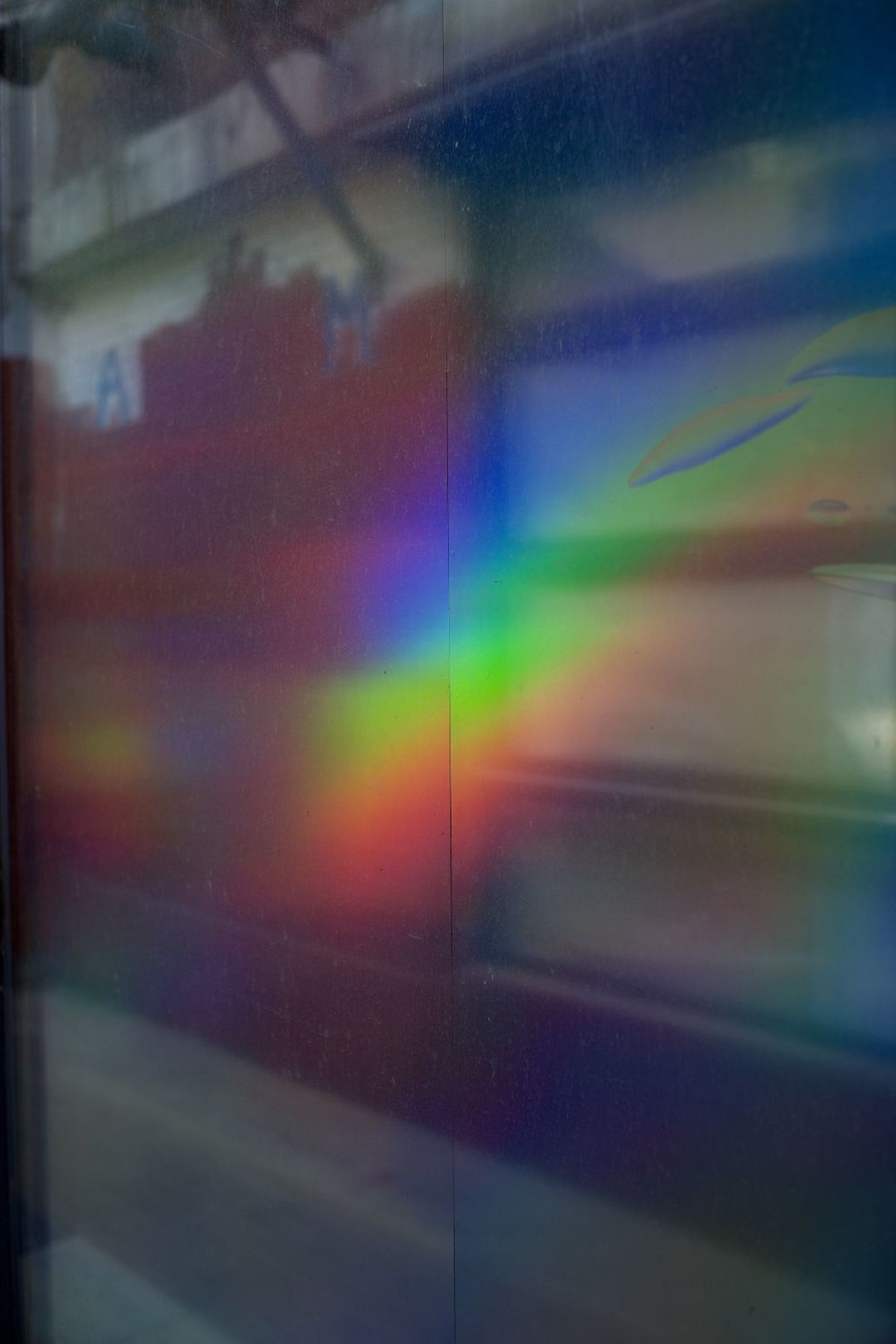 雨后的彩虹映射在窗户玻璃上的反射