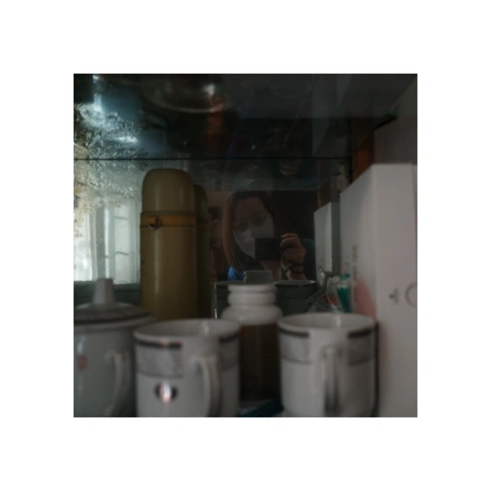 镜子里一个男人的身影和一个女人的身影 在一个有白色厕所的房间里。