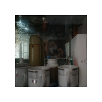 镜子里一个男人的身影和一个女人的身影 在一个有白色厕所的房间里。