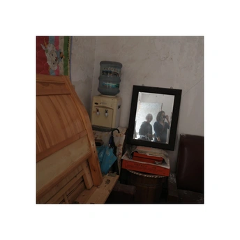 一个带有电视和镜子的卧室 镜子里有一个人物的照片。