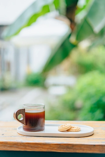 一小杯茶或咖啡放在外面桌子上的木托盘上