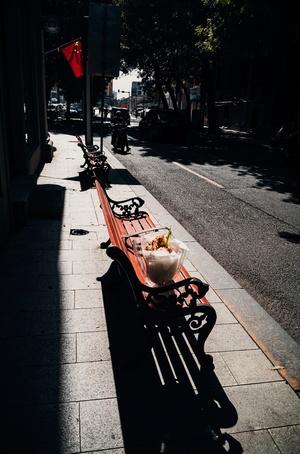 一条长凳上放着一个碗 它坐在空街上。