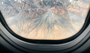 从飞机的窗户可以看到一座座山脉的景观。