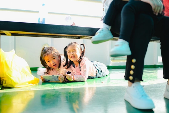 一个小女孩躺在地上 其他孩子在背景中玩耍。