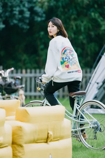 一位妇女骑自行车在草地上