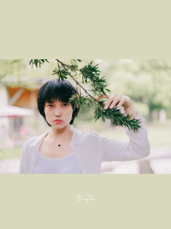 一位年轻女子抱着一棵树的树枝