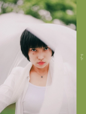一个戴白色面纱的年轻女子手持雨伞