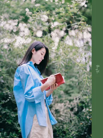 一位穿着蓝色和服的女性拿着一本红色的书